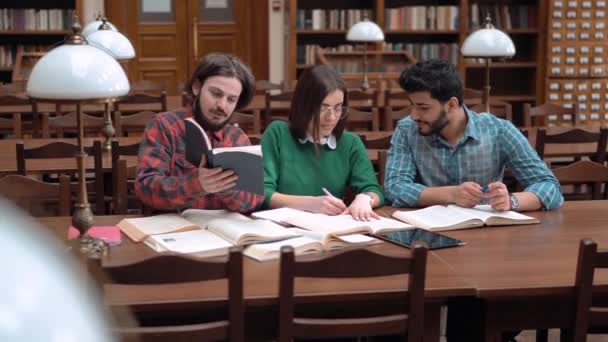 Grupo de estudiantes en la biblioteca — Vídeo de stock
