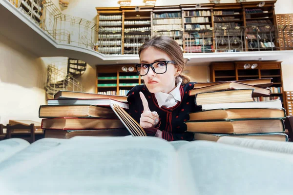 Chica con libros en la biblioteca — Foto de Stock
