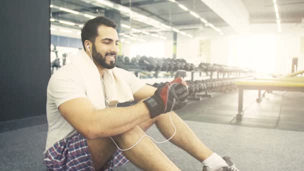 Man med telefonen i gymmet — Stockvideo