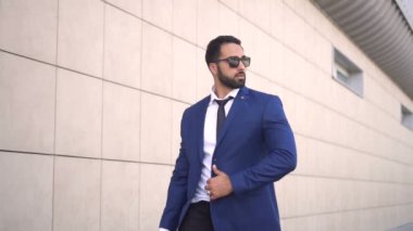 İşadamı yürüyüşler duvar boyunca sakallı