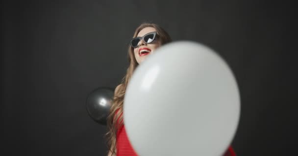 Luftballons fallen auf Dame in Rot mit Einkaufstasche — Stockvideo