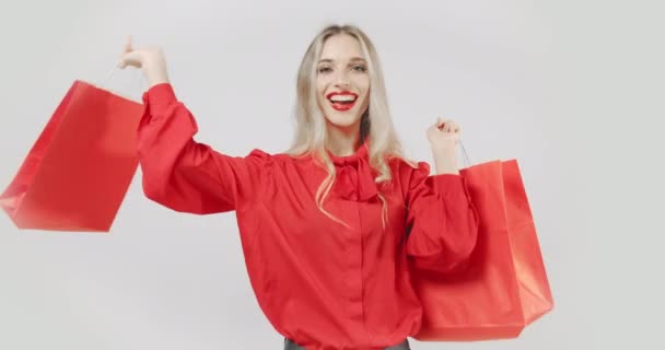 Mujer con bolsas de compras rojas sonriendo — Vídeos de Stock