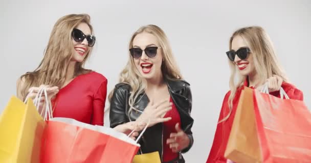 Mujeres felices con bolsas de compras rojas — Vídeo de stock