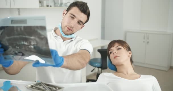 Dentista mostrando radiografía al paciente — Vídeo de stock