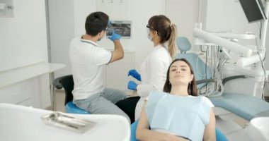 Hasta ile çalışan dişçi ve asistan.