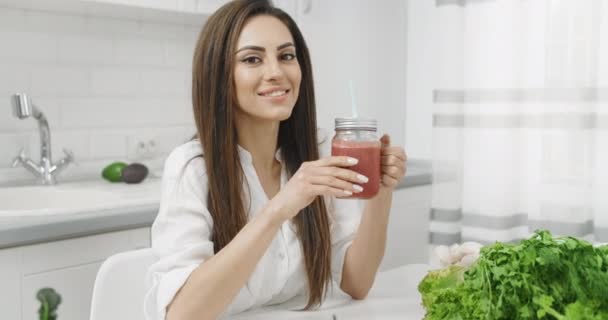 Mulher bebendo smoothie na cozinha — Vídeo de Stock