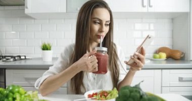Smoothie İçen ve Akıllı Telefonu Kaydıran Kadın