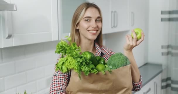 Женщина держит сумку с зелеными овощами — стоковое видео