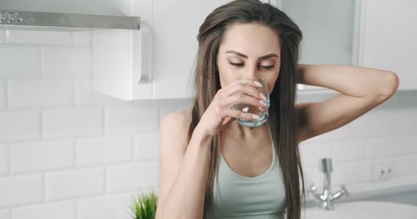 Vrouw drinken water na training keuken — Stockvideo