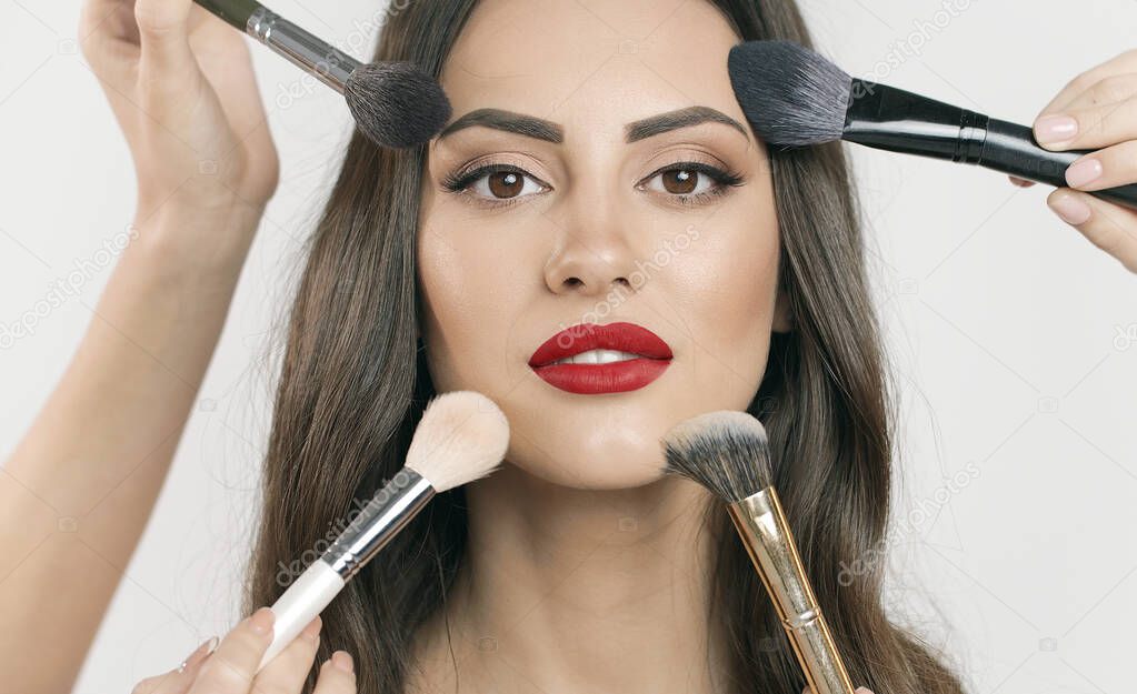 Chic Model Having Makeup with Multiple Makeup Brushes