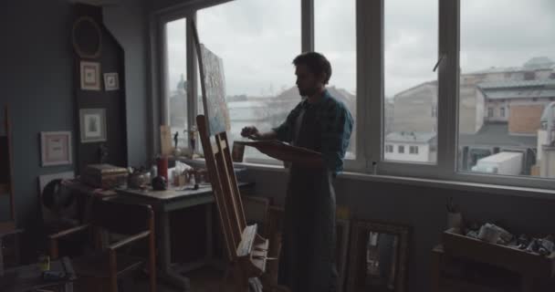 Man kunstenaar schilderen in atelier silhouet — Stockvideo