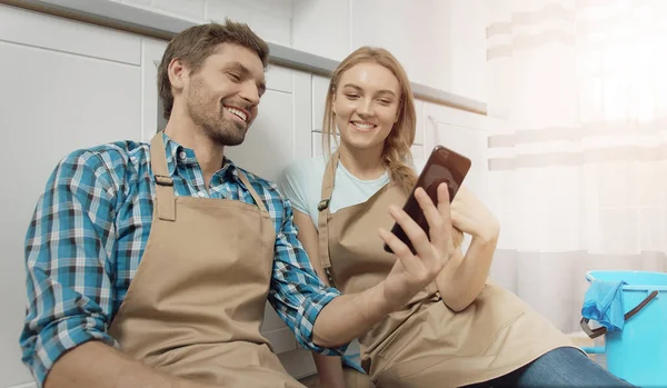 Feliz pareja cansada tiene un descanso después de la cocina limpieza Fotos de stock