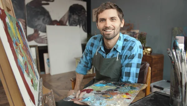 Young Handsome Male Artist Sitting at the Easel Royalty Free Stock Images