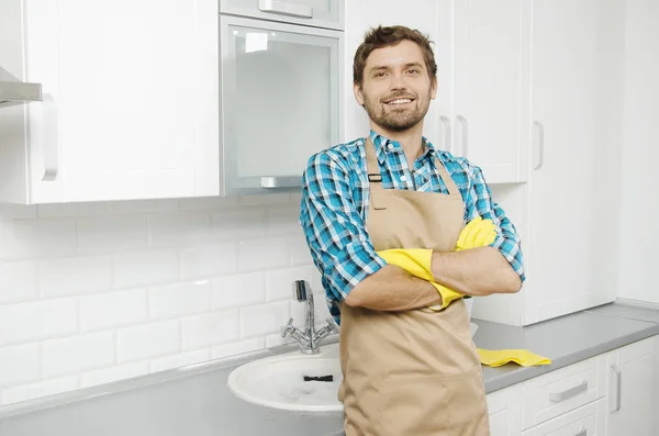 Smiling Young Bearded Brunet in Household Gauntlets and Apron Stok Gambar