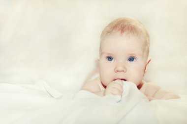 portret małego dziecka leżącego na koc