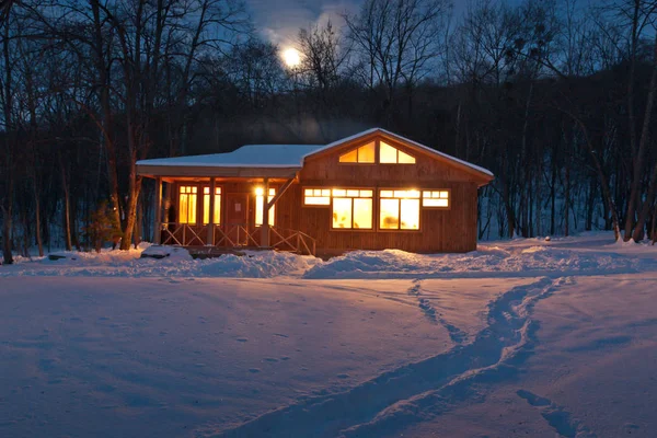 雪に覆われた森の中の小さな木造の家 — ストック写真