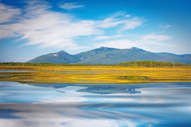 bulutlar cennet Dağları'nın eteklerinde bir yansıması ile masmavi Gölü