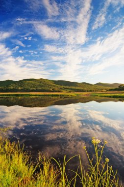 Suya yansıyan bulutların manzarası