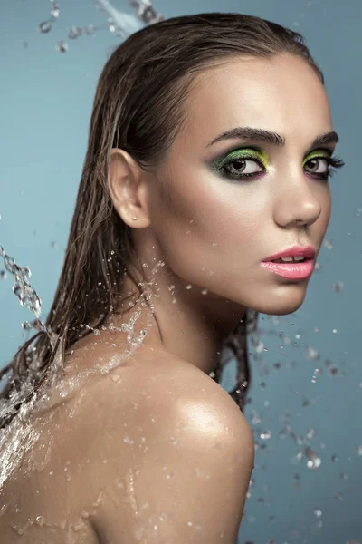 Ung Kvinna Med Fashionabla Makeup Poserar Vattenstänk Blå Bakgrund Royaltyfria Stockfoton
