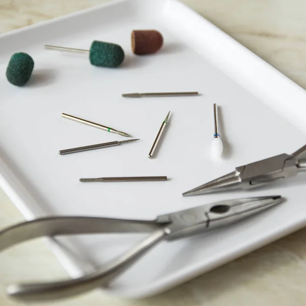 Tıbbi alet. Podoiogy, kırmızı ve yeşil kapaklar, kerpeten beyaz tıbbi tepsisindeki mermilerin