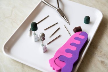 Tıbbi alet. Podoiogy, kırmızı ve yeşil kapaklar, kerpeten beyaz tıbbi tepsisindeki mermilerin. Freze kesici kasırga ve ayak