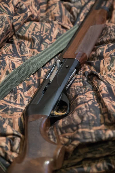 semi-automatic hunting rifle, close-up, camouflage jacket, green belt