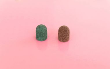 iki zımparalama matkap kapaklar. Yeşil ve kahverengi renkleri pembe arka plan üzerinde