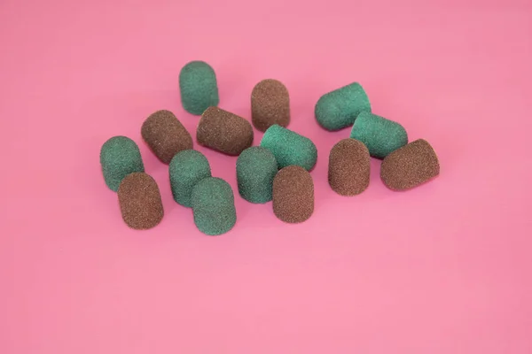 Kapaklar zımpara. Kahverengi ve yeşil renk pembe arka plan üzerindeki taşlama