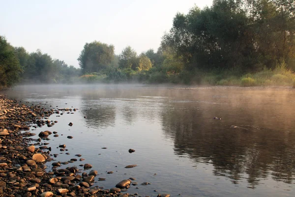 Brouillard sur la rivière Dnister. Tôt le matin, couleurs orange. Plage de galets et arbres sur les rives — Photo