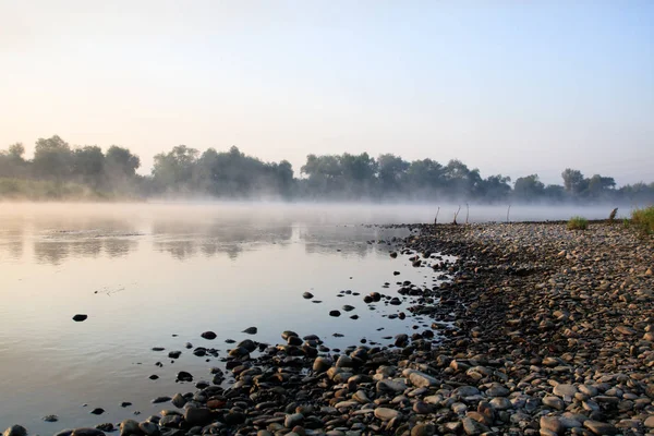 Fog on the river Dnister. Early morning, orange colors. Pebble beach, and twigs — Stock Photo, Image