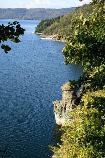 岩の海岸、緑の森と白遊覧船と青い水の湖の表示します。 — ストック写真