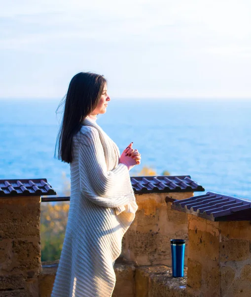 Young girl in a white cardigan admires a morning sea view from a top of the fortress — Stock Photo, Image