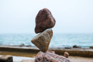 Deniz kenarındaki dengede kayalar, taşların yerçekimi dengesi.