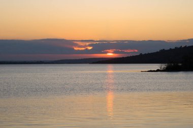 Gölde kırmızı gün doğumu, suda güneş izi