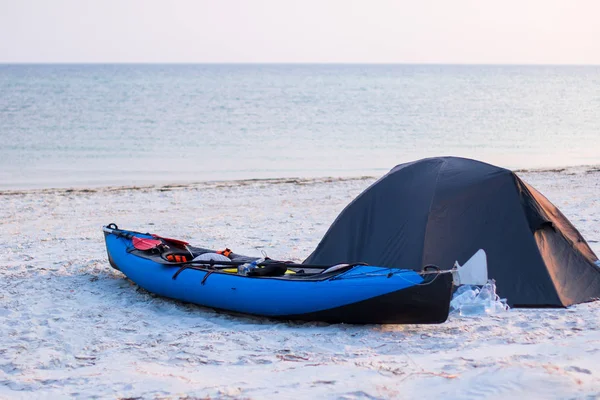 Kajak közelében egy sátor a strandon, a tenger közelében naplementekor — Stock Fotó