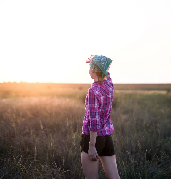 Fille aux cheveux roux passer du temps avec plaisir dans la prairie d'été au coucher du soleil — Photo