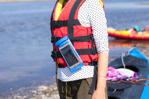 Gilet de sauvetage femme en rouge à la mer, kayaks en arrière-plan — Photo