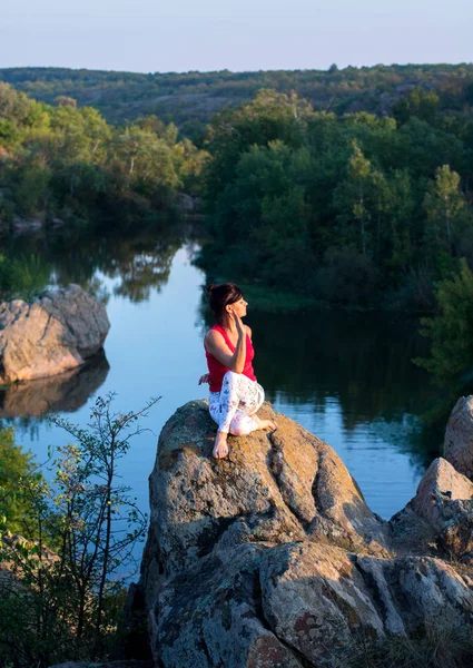 Adulte femme faire yoga asanas sur les rochers au-dessus de la rivière — Photo