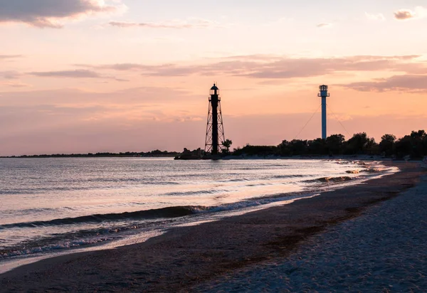 Gün batımında Djarylgach adasında eski ve yeni deniz fenerleri