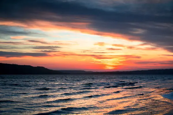 Orange and blue sunset on the lake with a small waves — Stock Photo, Image