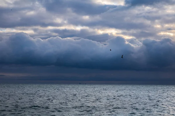 Modrá tmavá bouřková mračna nad mořem a loď na obzoru — Stock fotografie