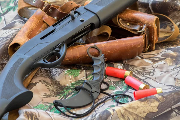 Vista de cerca de la escopeta de caza negro y cuchillo de karambit en el fondo de camuflaje — Foto de Stock