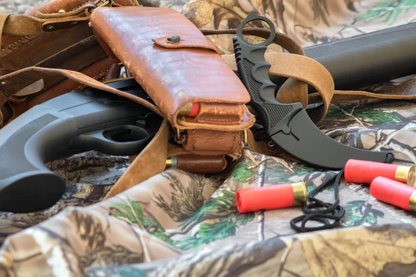 Vista de cerca de la escopeta de caza negro y cuchillo de karambit en el fondo de camuflaje — Foto de Stock