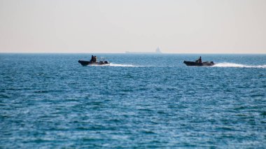 Açık denizde iki motorlu askeri tekne.