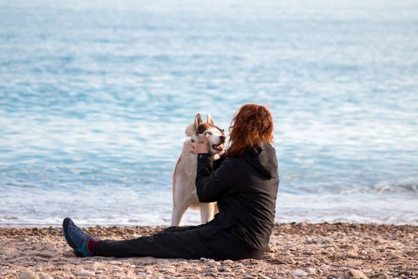 Ruda Dziewczyna Jest Zabawy Jej Husky Pies Żwirowej Plaży — Zdjęcie stockowe