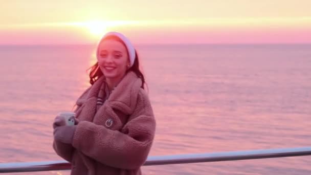 Lächelndes Junges Mädchen Pelzmantel Mit Tasse Kaffee Auf Der Strandpromenade — Stockvideo