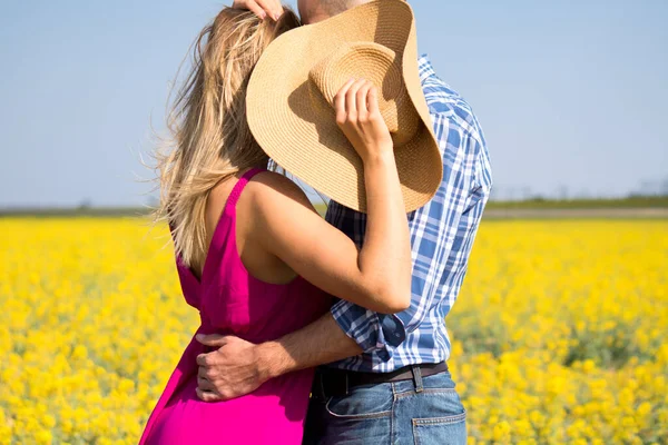 Sarı tarladaki genç beyaz çift öpüşüyor ve sarılıyorlar. Ekose gömlekli adam ve mor elbiseli kız.