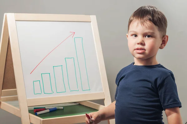 Ребенок стоит у доски с нарисованной диаграммой — стоковое фото