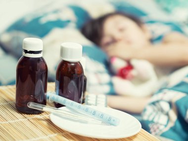 Hasta çocuk ve tıp yatağın yanındaki masada