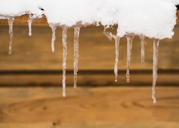 Long icicles hang from the roof of the house — Stock Photo, Image